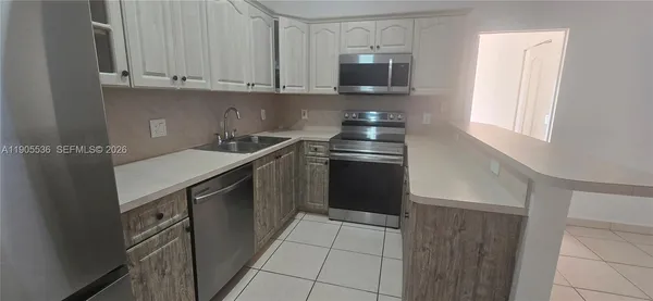 a kitchen with stainless steel appliances granite countertop a sink and a microwave