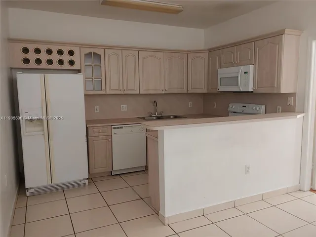 a kitchen with a sink a refrigerator and cabinets