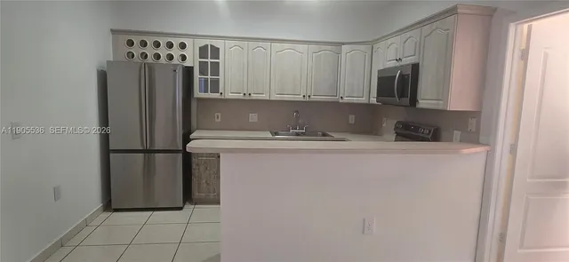 a kitchen with stainless steel appliances granite countertop a refrigerator and a microwave