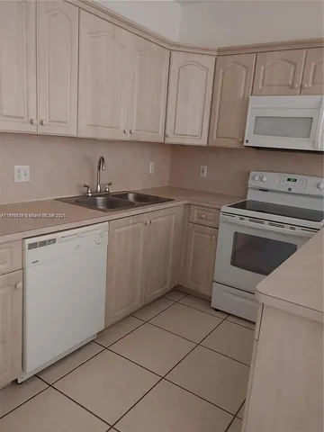 a kitchen with cabinets appliances and a sink