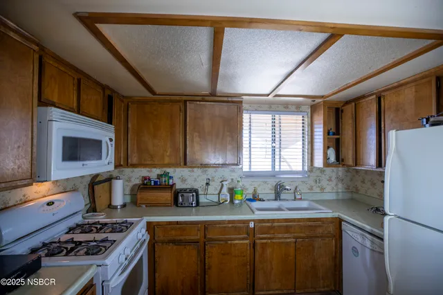 a kitchen with stainless steel appliances a stove a sink cabinets and a refrigerator