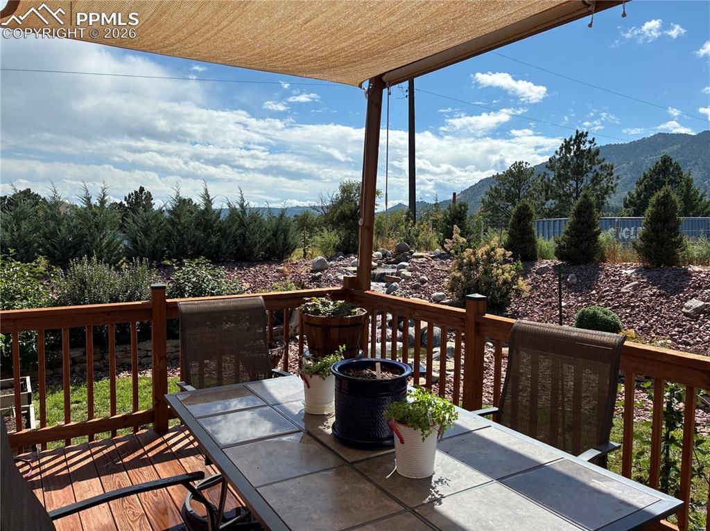 8480 Delaware Road Colorado Springs, CO 80926 - Photo 47 of 49 Summer 2025- Wooden deck featuring outdoor dining space and a mountain view