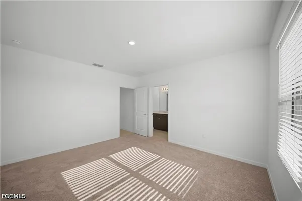 an empty room with a window and a kitchen
