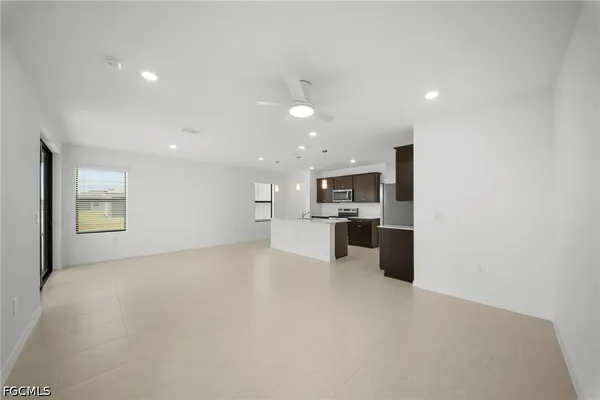 a view of a kitchen with a sink and dishwasher a refrigerator with white cabinets