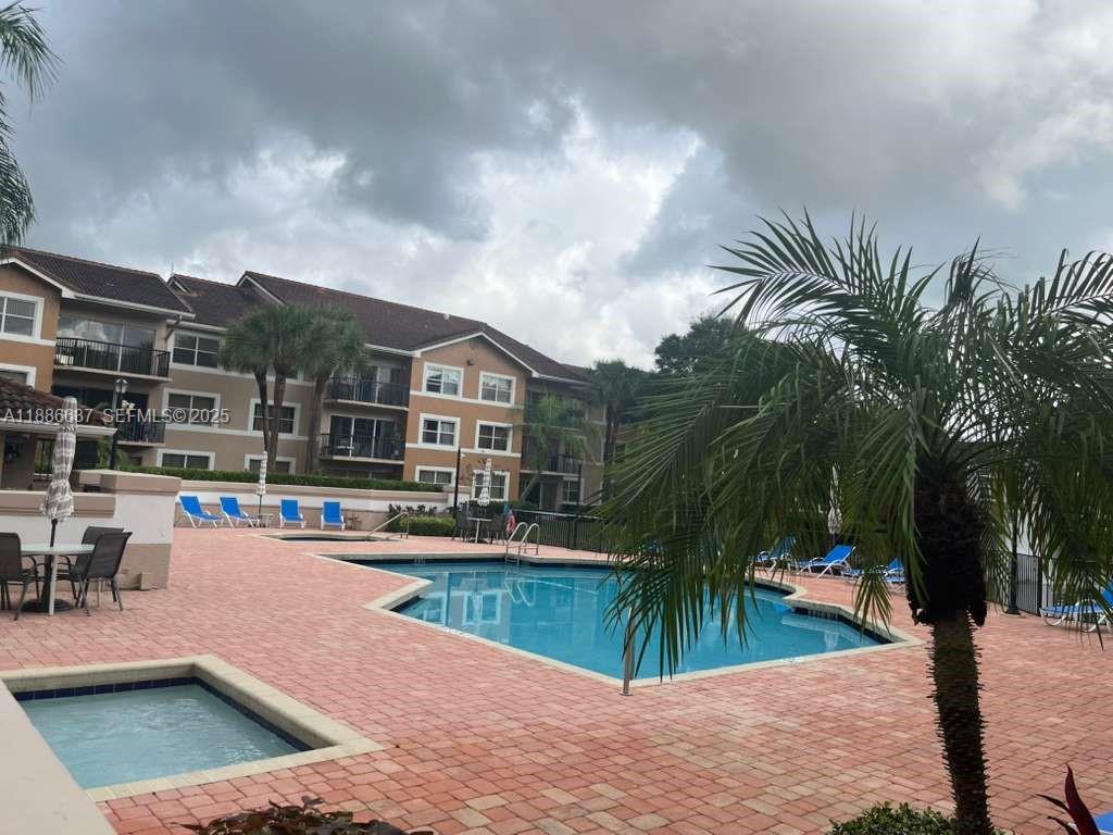 8801 Wiles Road, Unit 306 Coral Springs, FL 33067 - Photo 16 of 20 a view of a swimming pool with a patio and plants