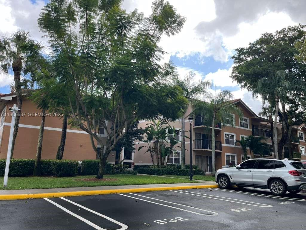 8801 Wiles Road, Unit 306 Coral Springs, FL 33067 - Photo 20 of 20 a view of a cars park on the side of a road