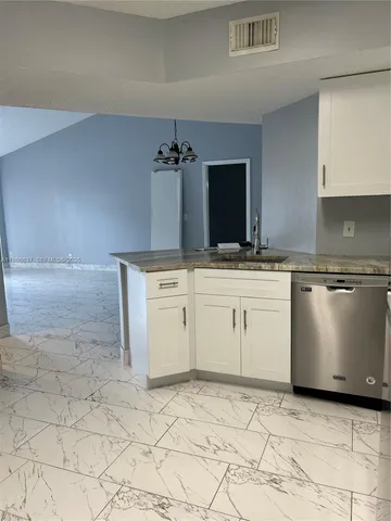 a kitchen with granite countertop white cabinets and white appliances
