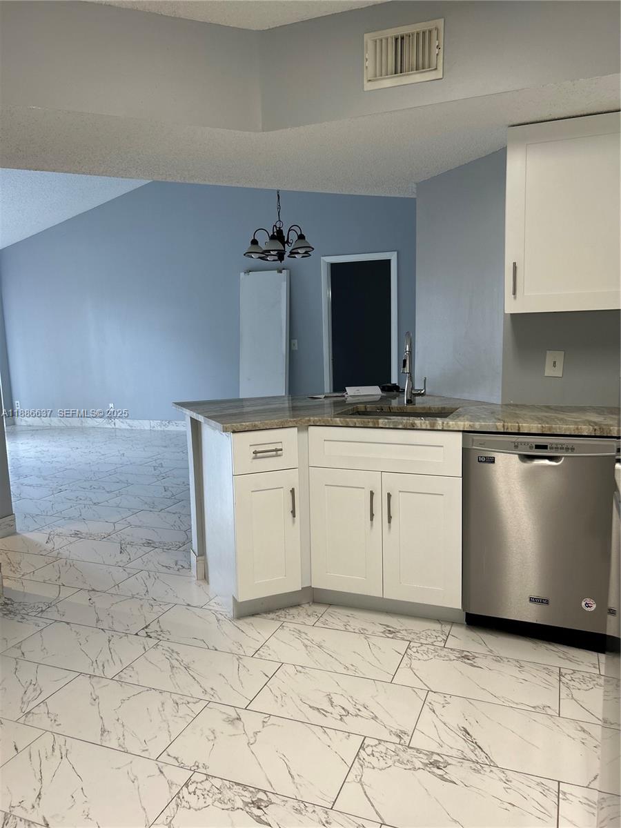 8801 Wiles Road, Unit 306 Coral Springs, FL 33067 - Photo 3 of 20 a kitchen with granite countertop white cabinets and white appliances