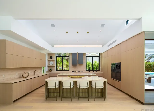 a dining hall with stainless steel appliances kitchen island granite countertop a sink and a refrigerator