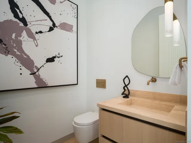 a bath room with a toilet a sink and a mirror