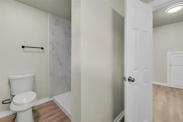 a bathroom with a toilet and a shower