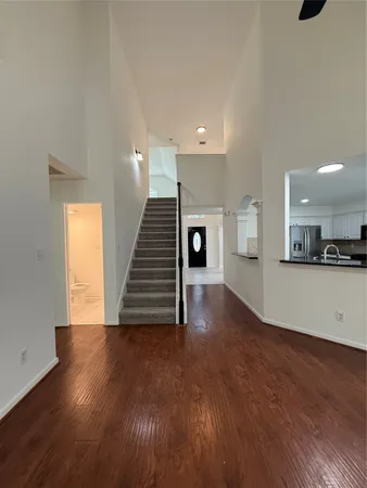 a view of a livingroom with wooden floor and stairs