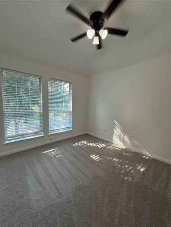 en empty room with windows and ceiling fan view