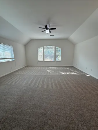 an empty room with windows and ceiling fan