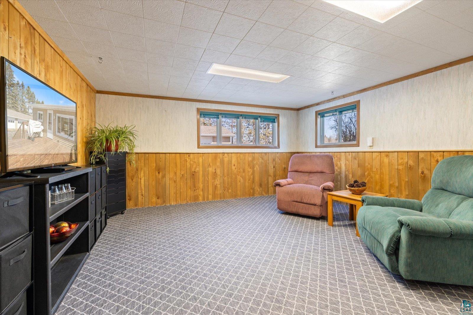 3495 Deer Forest Road Makinen, MN 55763 - Photo 31 of 71 Living area featuring wooden walls, ornamental molding, a wainscoted wall, and carpet