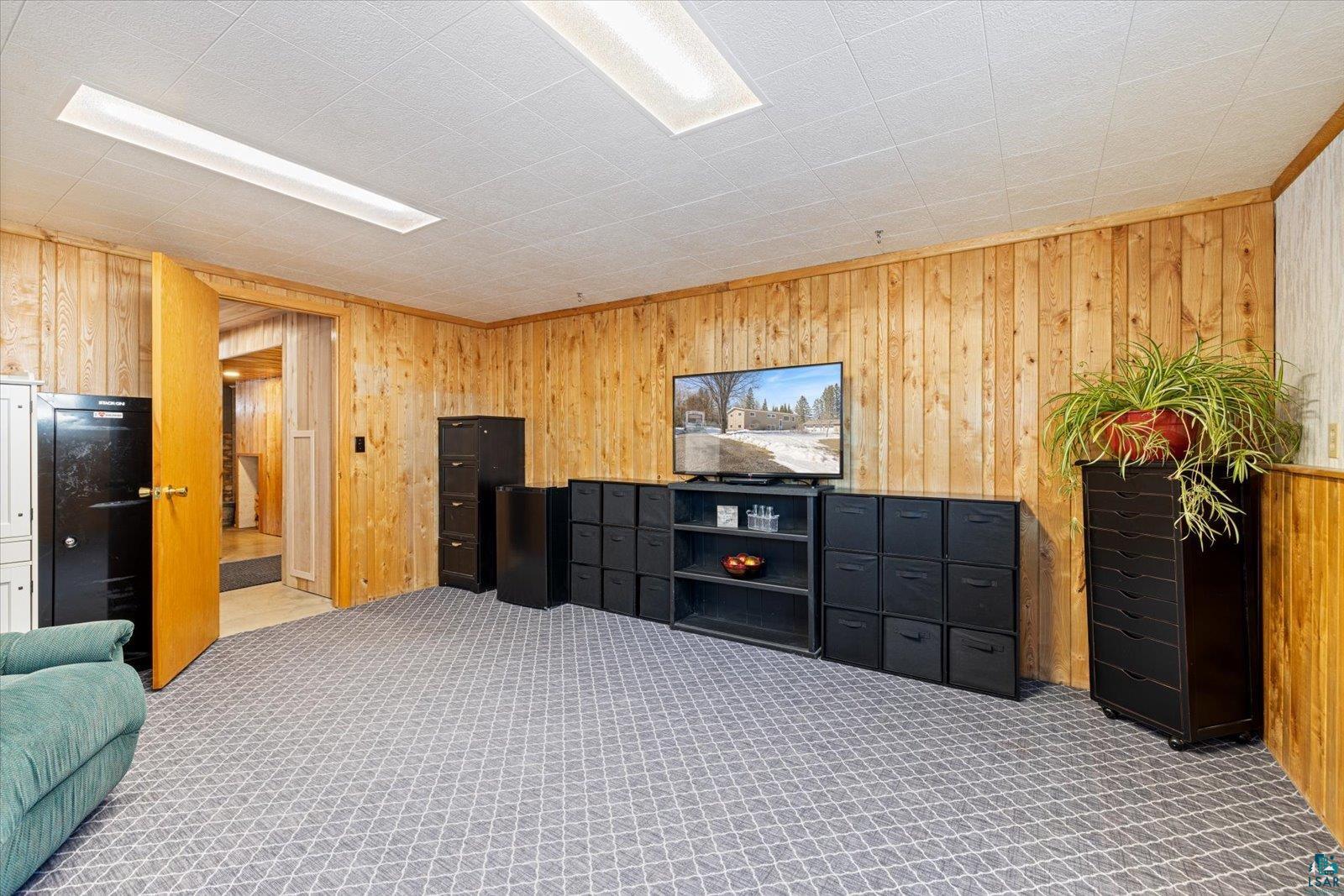 3495 Deer Forest Road Makinen, MN 55763 - Photo 10 of 71 Interior space featuring wood walls, light colored carpet, and refrigerator