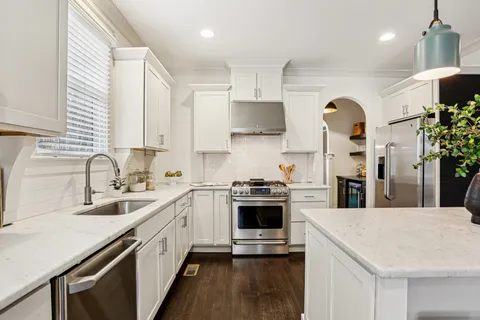 a kitchen with stainless steel appliances granite countertop a sink stove and refrigerator