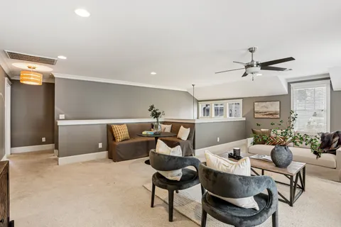 a living room with furniture and a ceiling fan