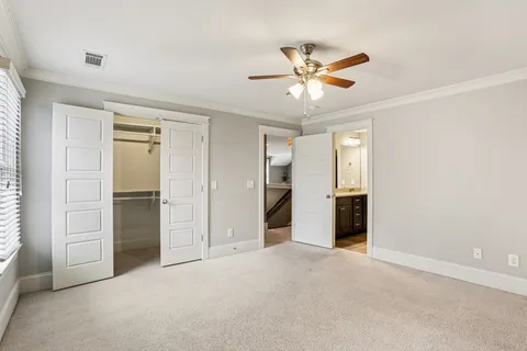 a view of an empty room with closet and a ceiling fan