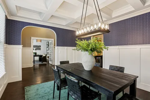 a view of a dining room with furniture a chandelier and wooden floor