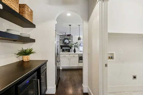 a kitchen with stainless steel appliances a white table chairs and a refrigerator