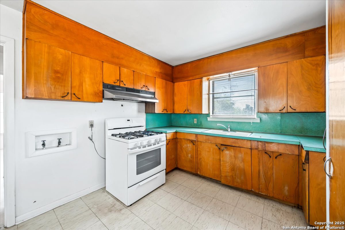 19239 McDonald Street Lytle, TX 78052 - Photo 13 of 29 a kitchen with stainless steel appliances granite countertop a stove a sink and a microwave