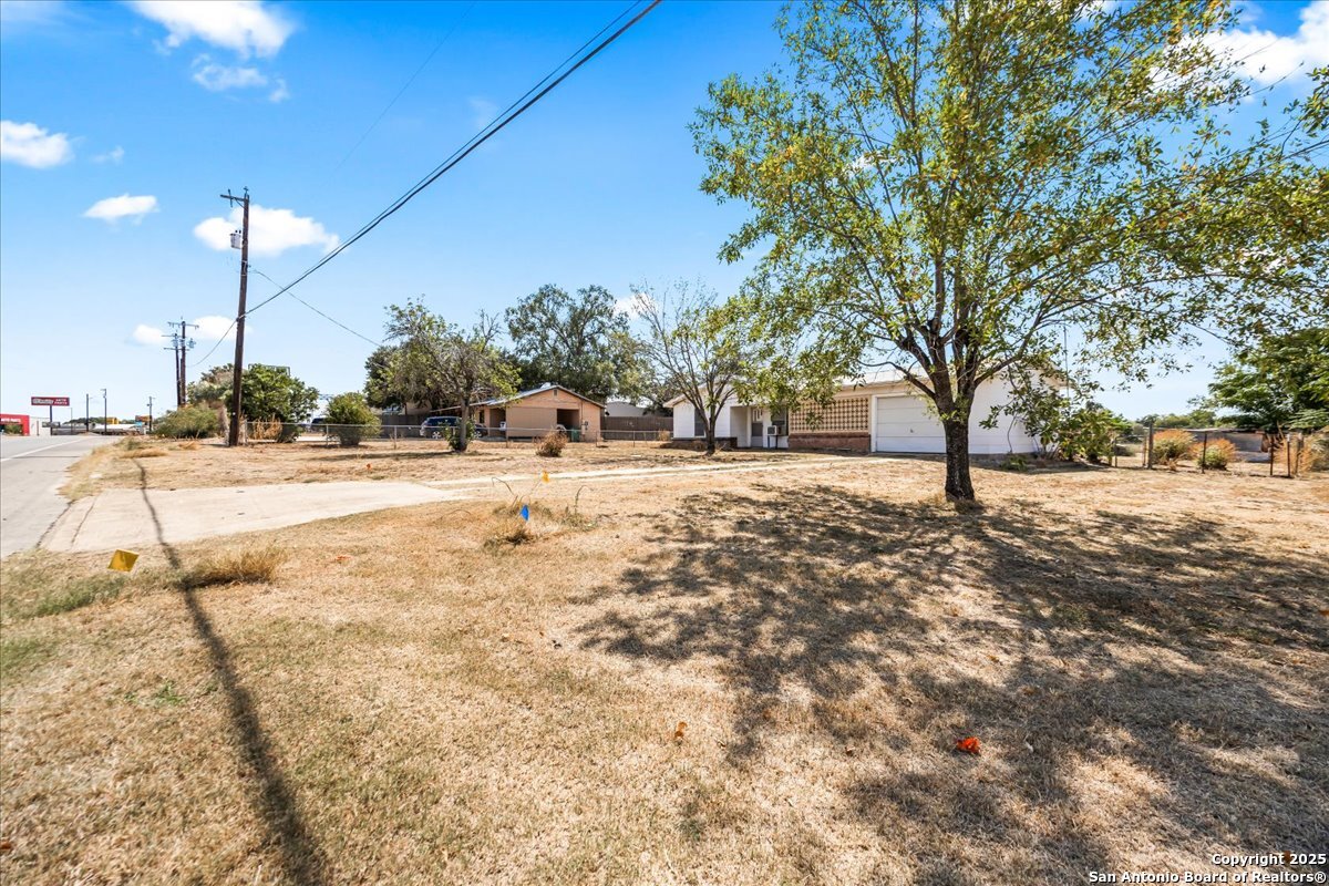 19239 McDonald Street Lytle, TX 78052 - Photo 3 of 29 a view of a yard with a tree