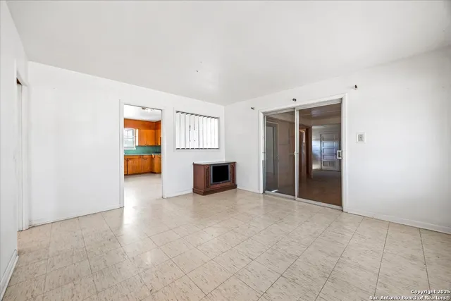an empty room with a kitchen and fire place