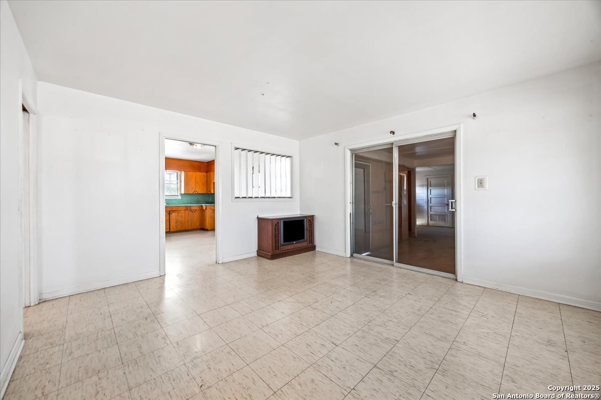 19239 McDonald Street Lytle, TX 78052 - Photo 6 of 29 an empty room with a kitchen and fire place