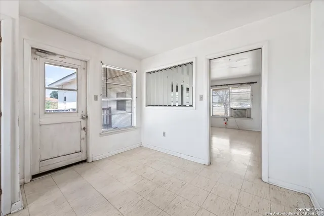 an empty room with windows and bathroom