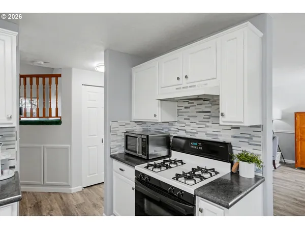 a kitchen with a stove a refrigerator and a cabinets