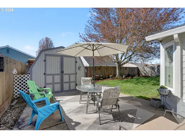 a view of a patio with a table and chairs under an umbrella