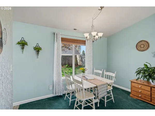a dining room with furniture a rug and a chandelier