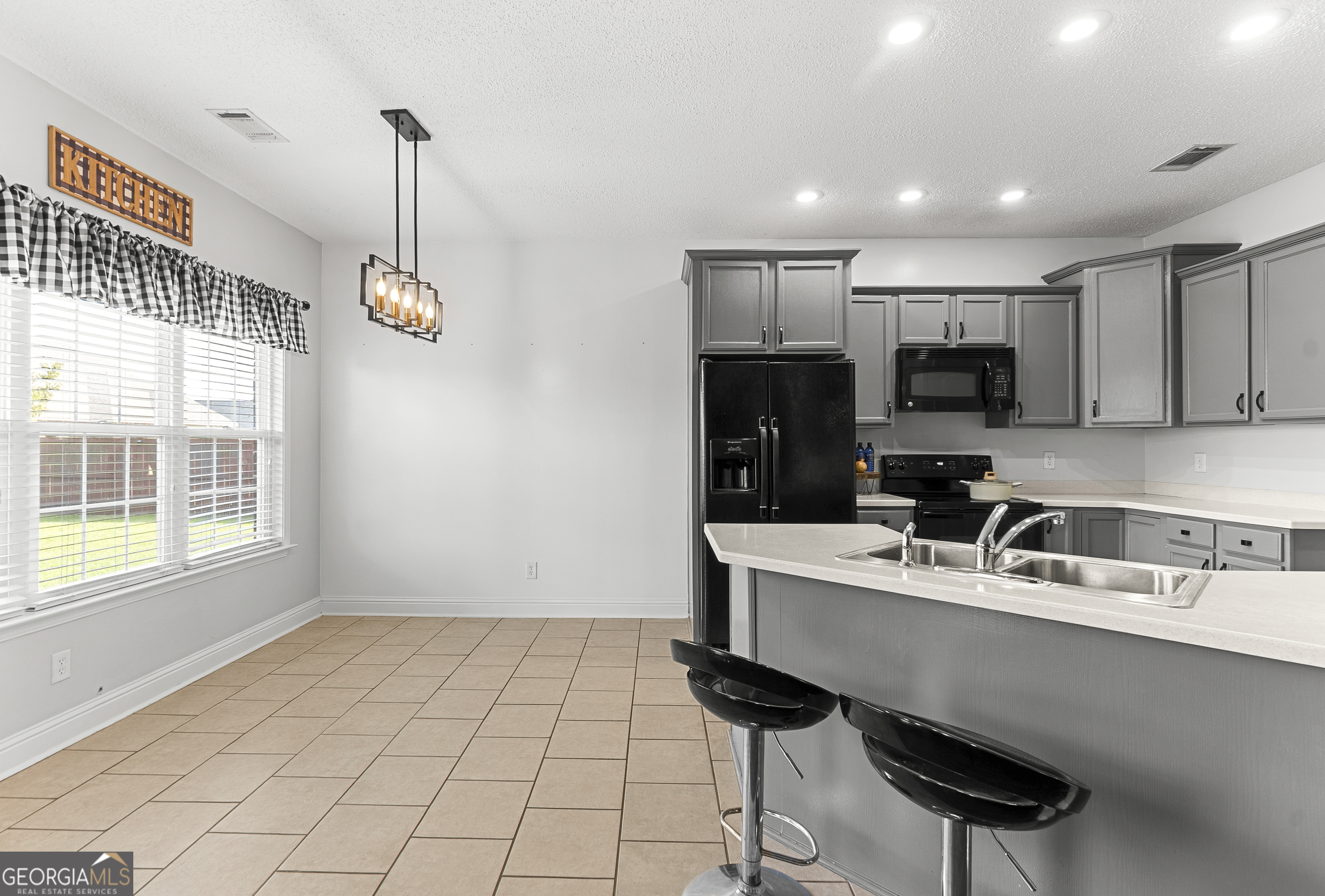 217 Caleb Way Byron, GA 31008 - Photo 16 of 58 a kitchen with stainless steel appliances a sink a stove a microwave a center island and cabinets