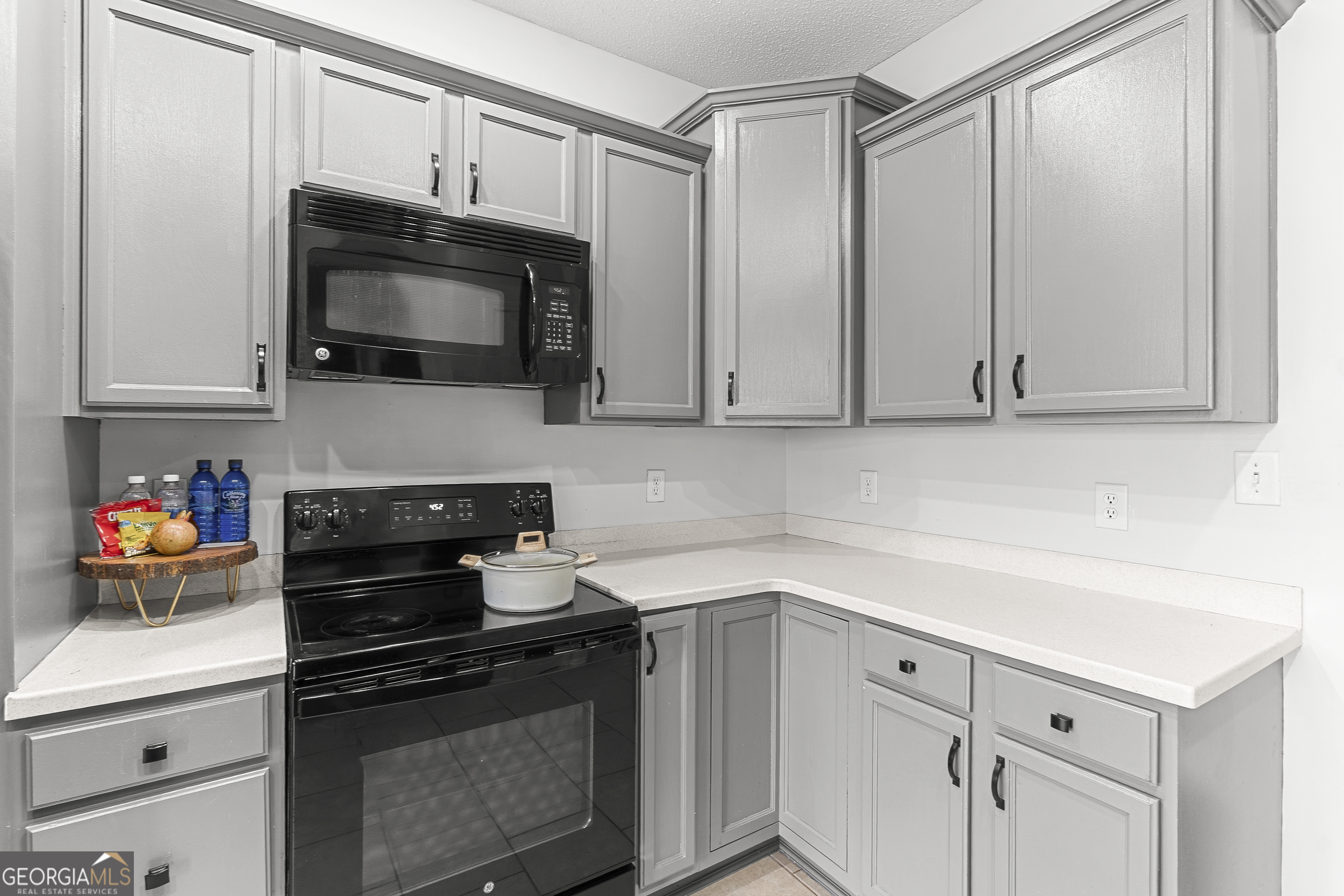 217 Caleb Way Byron, GA 31008 - Photo 21 of 58 a kitchen with white cabinets and black appliances