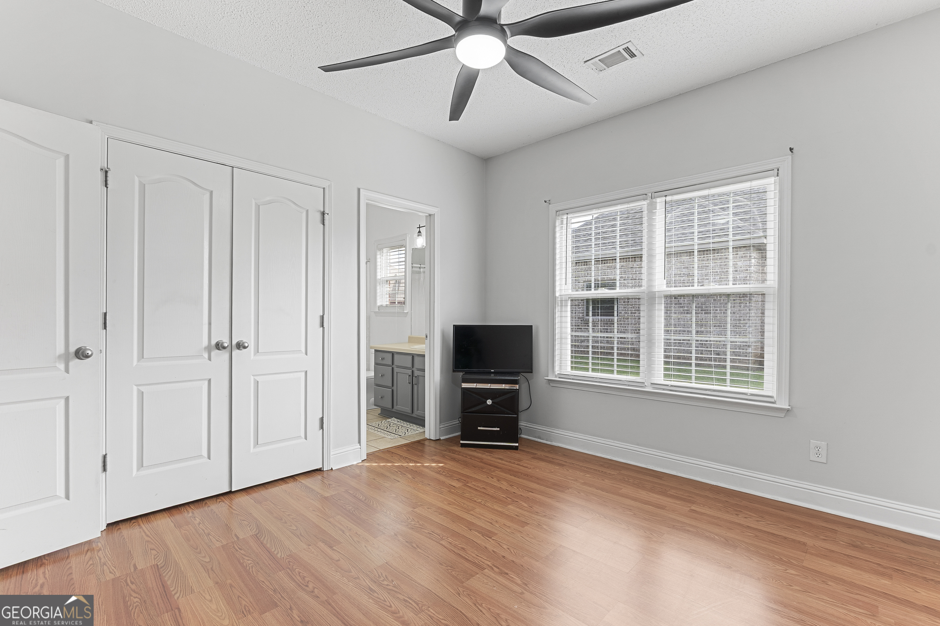 217 Caleb Way Byron, GA 31008 - Photo 43 of 58 wooden floor in an empty room with a window and a kitchen