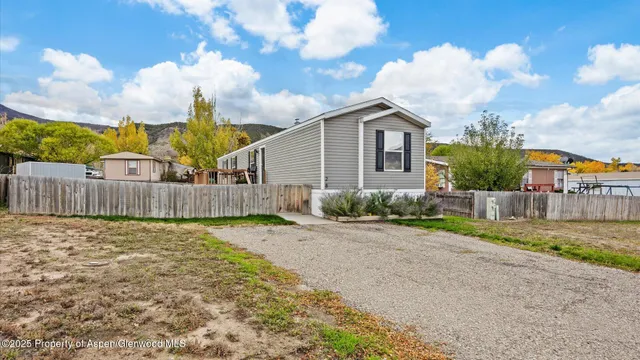 a view of a house with a big yard and large tree
