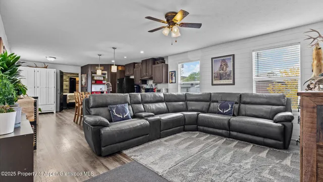 a living room with furniture a ceiling fan and a window