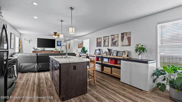 a living room with stainless steel appliances kitchen island granite countertop furniture a rug and a window