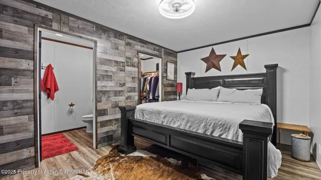 a bed sitting in a bedroom next to a bathroom