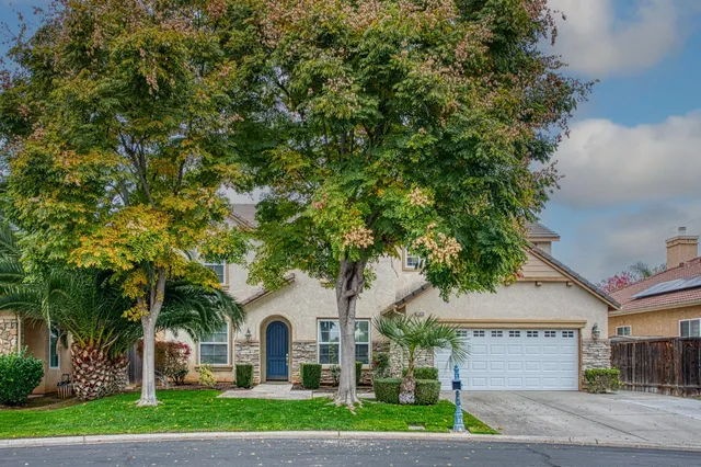 a white house with a tree in front of it