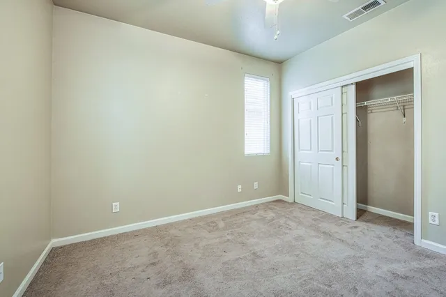 an empty room with windows and closet
