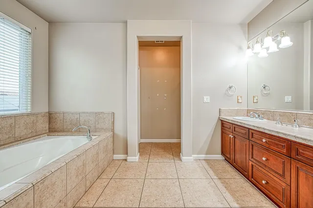 a spacious bathroom with a granite countertop tub sink and a mirror
