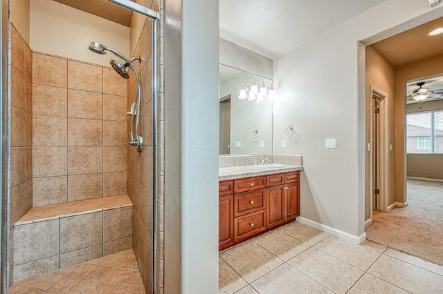 a bathroom with a granite countertop sink mirror and shower