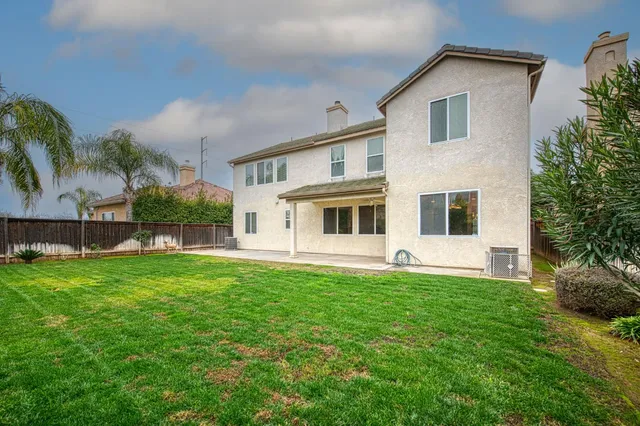 a white house that has a big yard in front of it