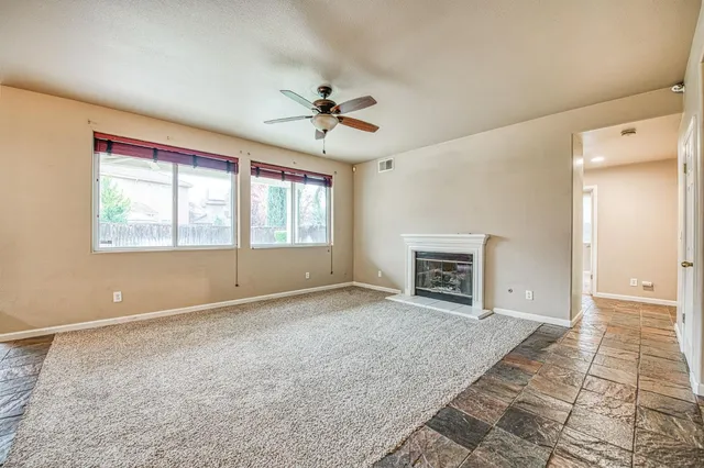 a view of an empty room with a window and fireplace