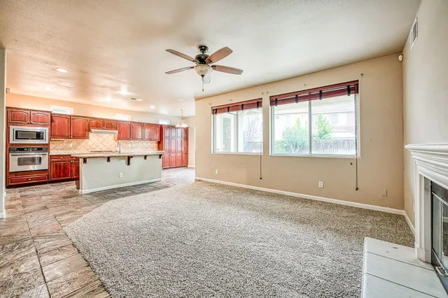 a living room with stainless steel appliances furniture and a window