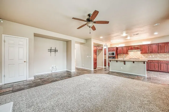 a living room with stainless steel appliances kitchen island furniture and a window