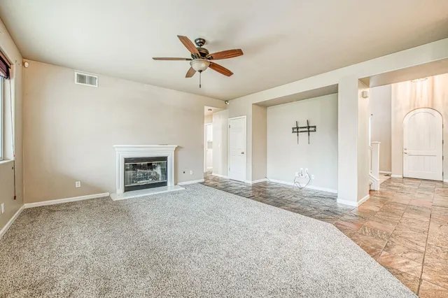 a view of empty room with fireplace and window