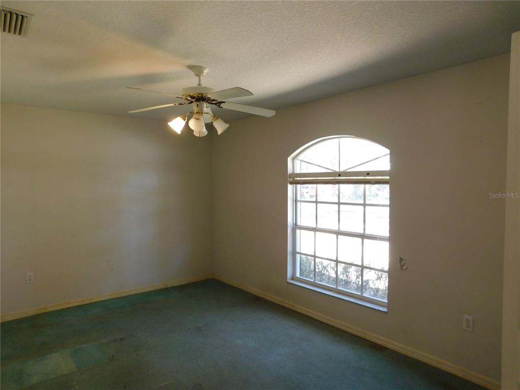 5821 Buck Run Drive Lakeland, FL 33811 - Photo 11 of 30 an empty room with chandelier fan and windows